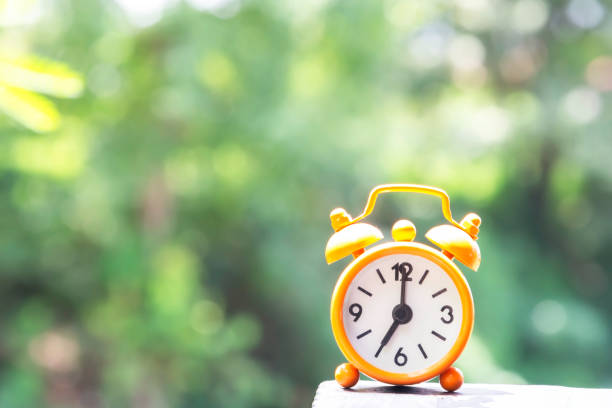 Alarm clock on wooden table with bokeh in background