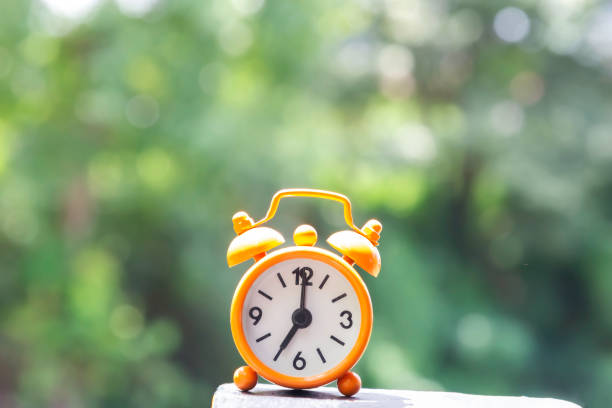 istock Alarm clock on wooden table with bokeh in background 2148102614