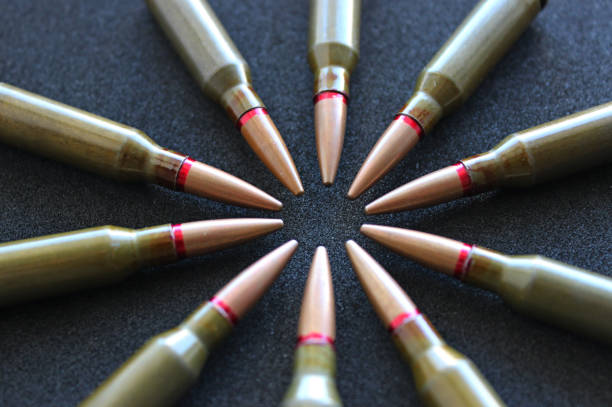 Circle Made With Bullets Laid Out In Head To Head Order On Black Surface