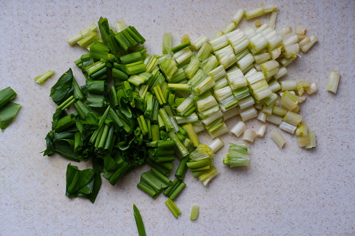 For cooking, wild garlic leaves are finely chopped. Fresh wild garlic closeup on a kitchen board