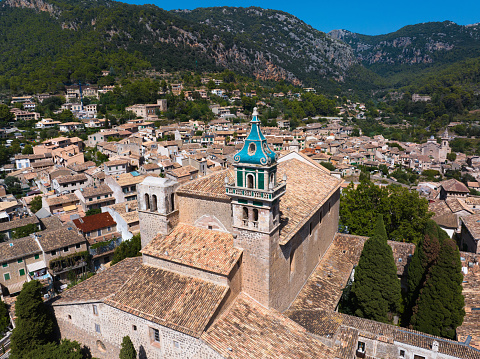 Valldemossa Charterhouse built in 14th century in the old town of  Valldemossa Village. Aerial Drone Detail View overlooking the old town of Valdemossa. Church Tower of Valldemossa Charterhouse in the Center. Valldemossa, Majorca Island, Balearic Islands, Catalonia, Spain