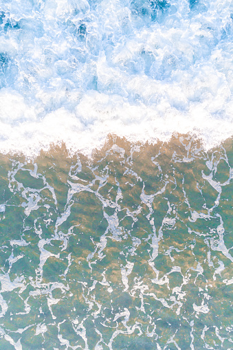 close up view of the sea water reaching the shore of the beach, texture for backgrounds