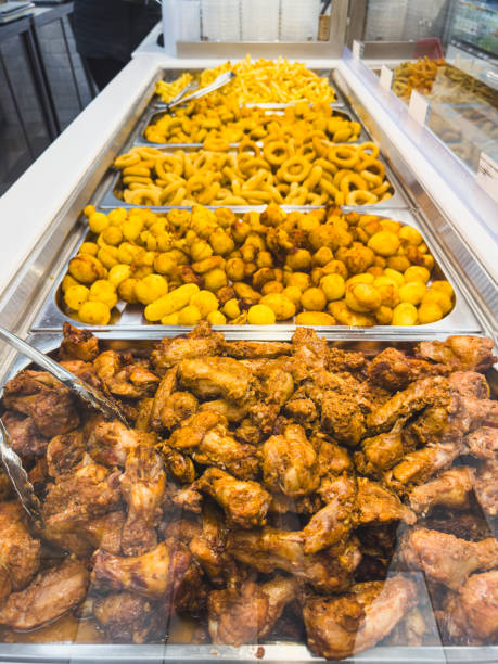 Fried chicken wings and potatoes on a counter in a market