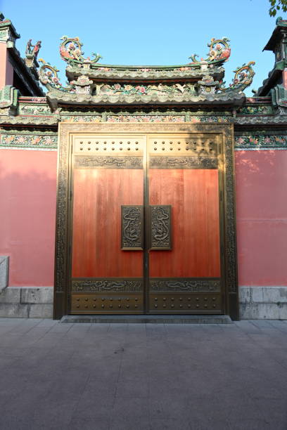 A low-angle shot through an archway provides a detailed view of a traditional Chinese building with a vibrant, colorful facade.