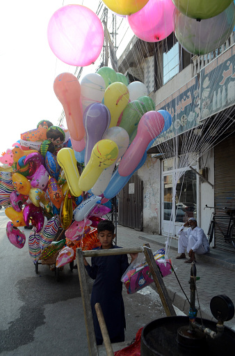 rawalpindi pakistan: a child vendor sells balloons to earn his livelihood at a roadside located on eidgah shreef road in rawalpindi on wednesday april 10,2024
