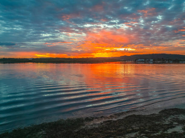 istock Sunrise over the bay water with clouds and reflections 2148106595
