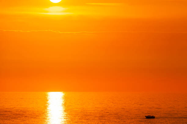 istock Motor boat on still sea at sunset 2148107712