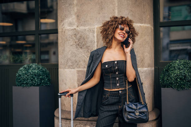 istock Stylish young woman chatting on phone in urban setting 2148109364