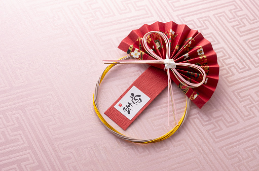 Chinese New Year Ornament. Chinese Zodiac Sign Year of Ox. Red artificial plum blossom, origami paper semicircle and Ox symbol of 2021 on blue background, free space for text, minimalism.