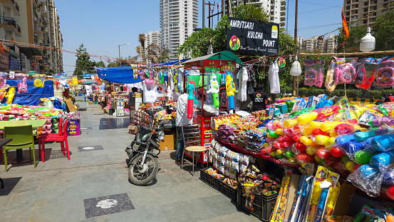 Noida, India - March 23 2024: Holi festival articles shops in market area.