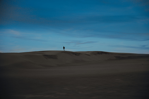 Blue hour on the Dune du Pilat with a man walking in the background.