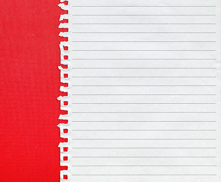 Torn spiral notebook page paper on red paper background textured.