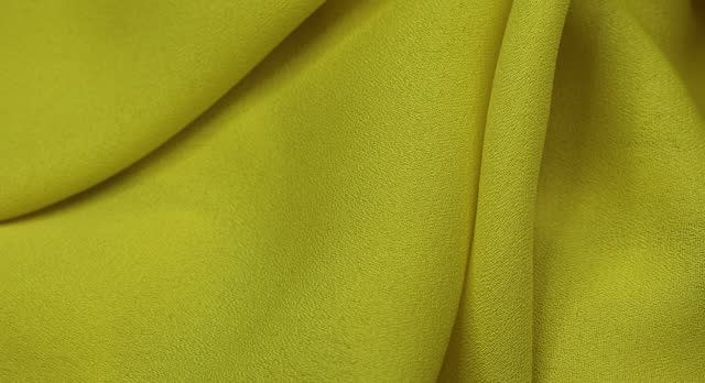 Yellow fabric background. Yellow cloth waves background texture. Yellow fabric cloth textile material.