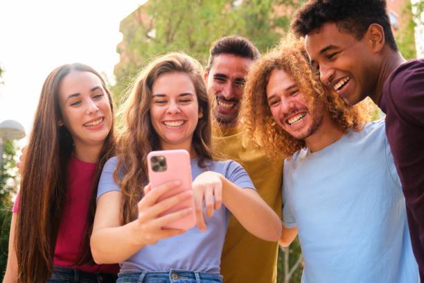 istock Group of young friends having fun sharing media with a cellphone. 2148112721