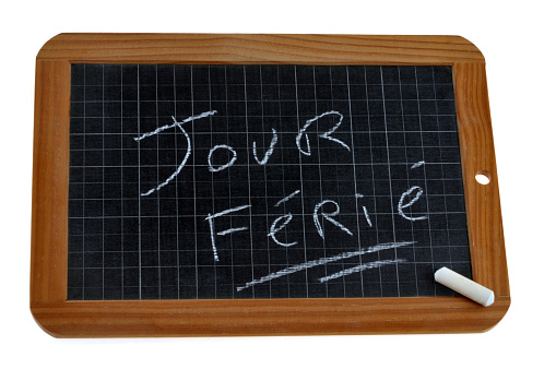 School slate on white background on which public holiday is written in french with chalk