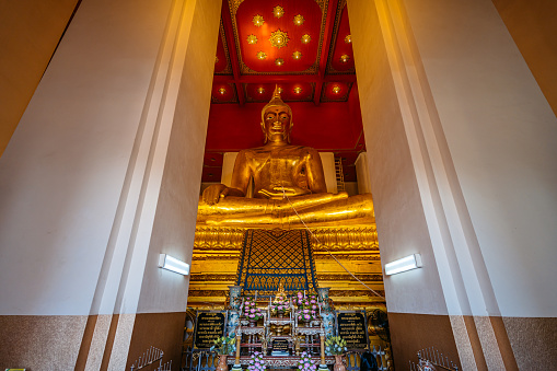 The sitting buddha statue inside of Wihan Phra Mongkhon In Ayutthaya in Thailand.