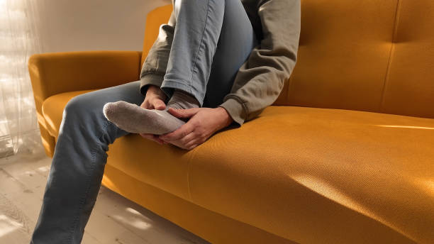 istock Man with ankle and foot pain at home. 2148115504