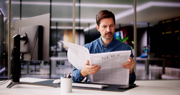 istock Businessman Reading Newspaper At Office Desk 2148115674