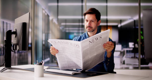 istock Businessman Reading Newspaper At Office Desk 2148115681