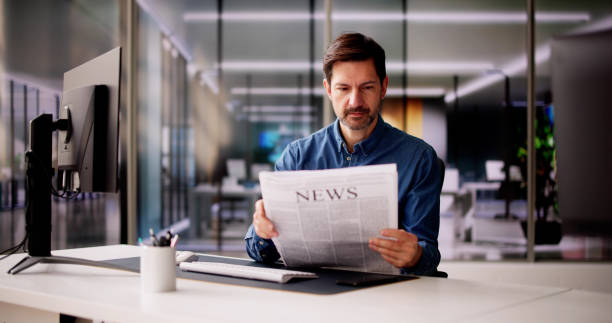 istock Businessman Reading Newspaper At Office Desk 2148115682