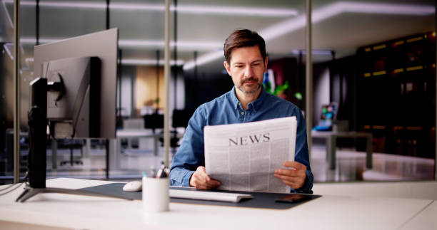 istock Businessman Reading Newspaper At Office Desk 2148115688