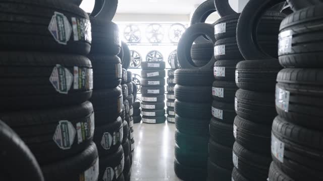 Stock of tires and rims on shelves at an auto repair shop