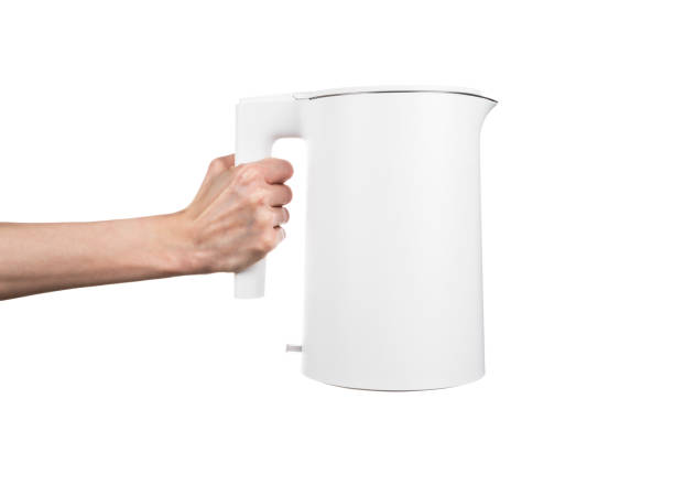 istock New modern electric kettle in female hand isolated on white background 2148116354