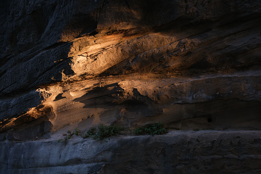 Last rays of light falling on a rock wall.