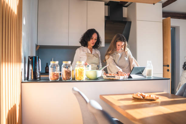 istock Multigenerational Female Family Members Cooking and Using Laptop in Kitchen 2148117577