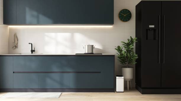 Modern dark teal blue kitchen counter cabinet, cupboard with sink, induction stove, refrigerator in sunlight on white tile splash back