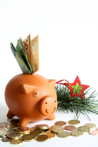Concept of save money. Piggy bank with euro banknotes and coins on white background. Christmas decoration. Copy space.
