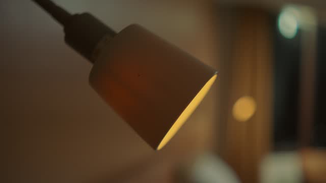 Close-up of a modern lamp against a blurred background, with a warm and cozy ambiance.