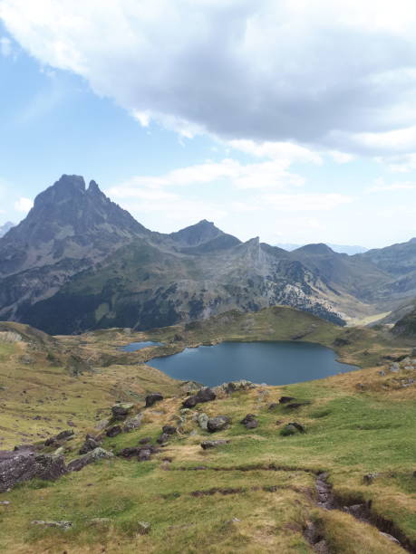 istock Natural scene: mountain lake and rocky peak, with thick clouds, sunny day 2148121552