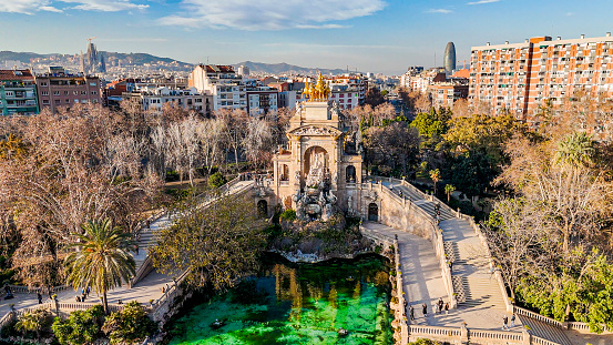 Aerial view of Carro de la Aurora fountain in Barcelona, Quadriga de l'Aurora on top of Font de la cascada, Ciutadella Park Fountain, Plaça de Sonia Rescalvo Zafra. Ciutadella Park. Barcelona, Spain. Neptune. Naixement of Venus

The Parc de la Ciutadella is a park on the northeastern edge of Ciutat Vella, Barcelona, Catalonia, Spain. For decades following its creation in the mid-19th century, this park was the city's only green space. The 31 hectares grounds include the Palau del Parlament de Catalunya, a small lake, and a large fountain designed by Josep Fontserè (with possible contributions by the young Antoni Gaudí).
As the location of the Parliament of Catalonia, the tensions in 2018 and 2019 regarding Catalan independence regularly led to the police closure of the park to public access to prevent crowds forming near to the official buildings.