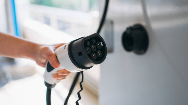 istock Close up hand of plugging electric car at a charging station. 2148122021