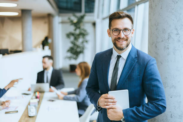 istock Confident businessman in office with colleagues 2148122353