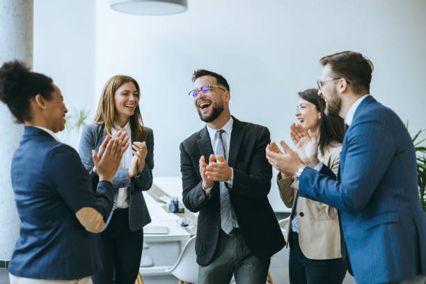Office team applauding a happy colleague