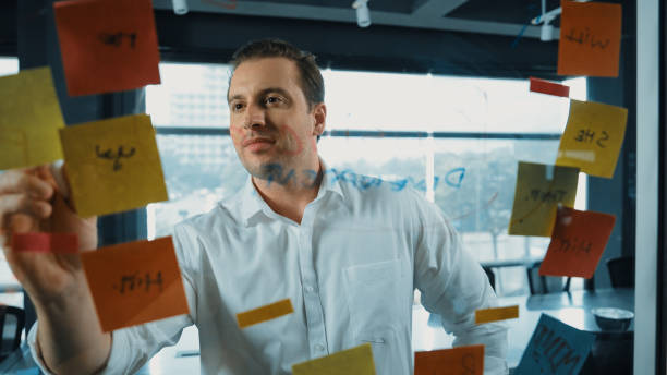 istock Professional male leader writing marketing idea on sticky notes. Manipulator. 2148122701