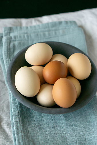 Brown and beige chicken eggs in a bowl. Organic.