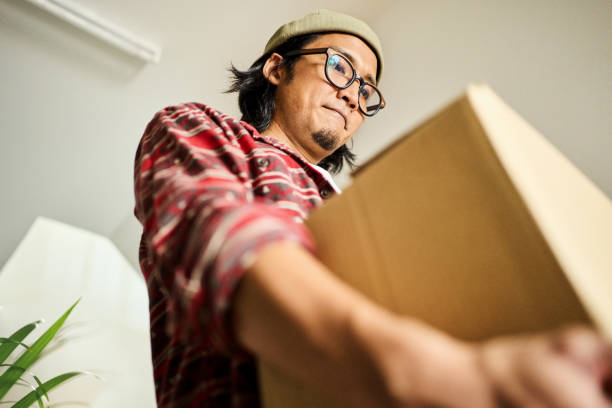 istock Young man carrying box on steps in his new home 2148126963