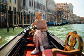 Woman on a gondola tour sailing in Grand Canal in Venice, Italy