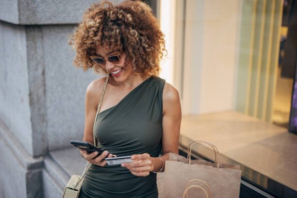 istock Joyful woman shopping and using smartphone in city 2148127690