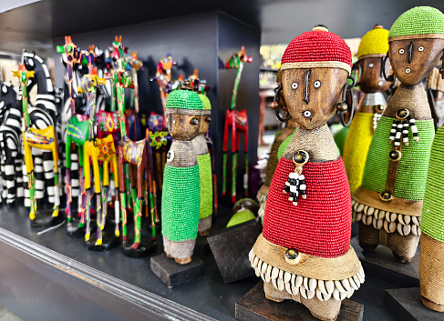 Traditional African wooden hand made dolls and colorful bead decoration at local craft market in Nairobi, kenya.