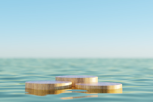 3d rendering of product presentation stand displaying surreal wooden round floating objects on seawater surface against sunset sky background