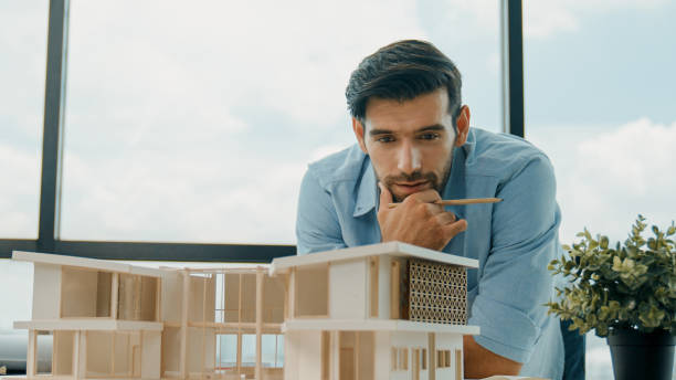 istock Closeup of skilled engineer check, inspect, look at house model. Tracery 2148132736
