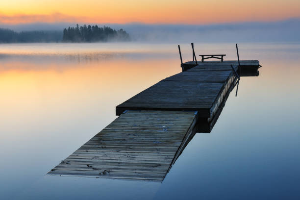istock Wooden jetty floating on a calm and misty lake 2148132775
