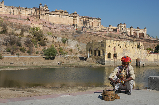 Jaipur, Rajasthan, India - March 03, 2006: Snake charmer by Maotha Lake in front of Amber Fort
