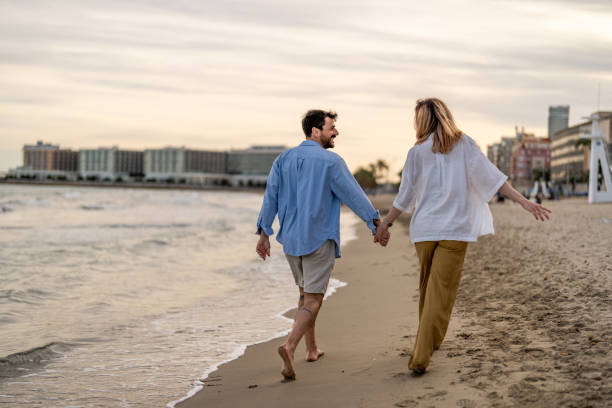 istock Woman and man holding hands at the seaside 2148133108