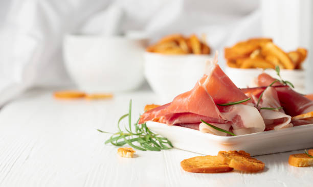 istock Prosciutto with rosemary and spicy bruschetta crackers. 2148133496