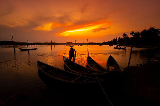 Traditional fishermen and boats at O Loan lagoon in sunset, Phu Yen province, Vietnam. Travel and landscape concept